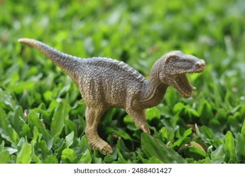 Dinosaur Best Photograph Toy Opens Its Mouth and Steps on the Grass Stock Photo