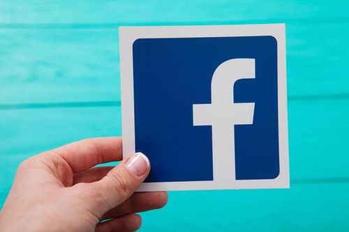 KIEV, UKRAINE - MARCH 10, 2017. Facebook logotype printed on paper. Woman holding in hand Facebook logo. Facebook popular social networking service. Selective focus. photo