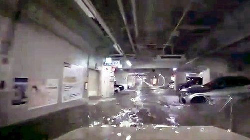 浸水した「くすの木パーキング」の出口に向かう男性の車（手前、男性提供）