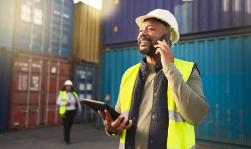 Logistics, shipping and construction worker on the phone with tablet in shipyard. Transportation engineer on smartphone in delivery, freight and international distribution business in container yard Logistics, shipping and construction worker on the phone with tablet in shipyard. Transportation engineer on smartphone in delivery, freight and international distribution business in container yard importing stock pictures, royalty-free photos & images