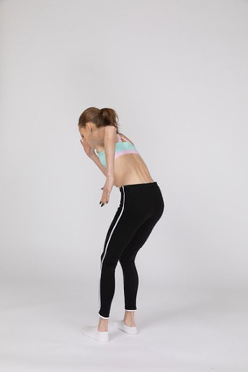 四分之三后视图的运动服向前倾斜，而站在像机器人一样的青少年女孩