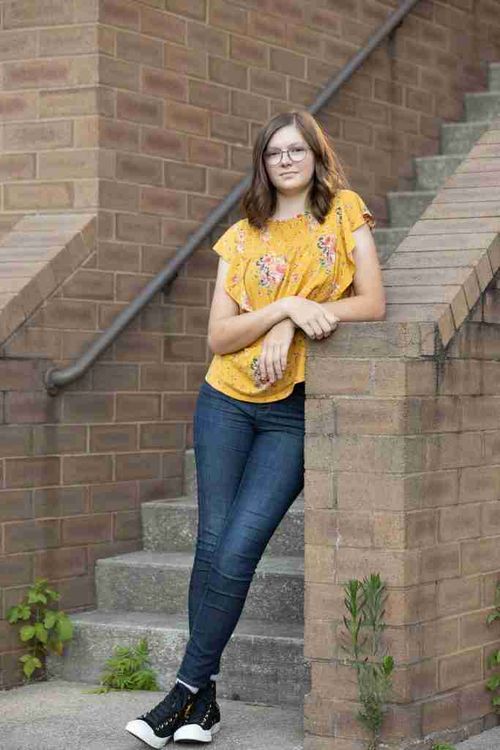 A cute girl pose with a girl in a yellow blouse leaning on a stairwell