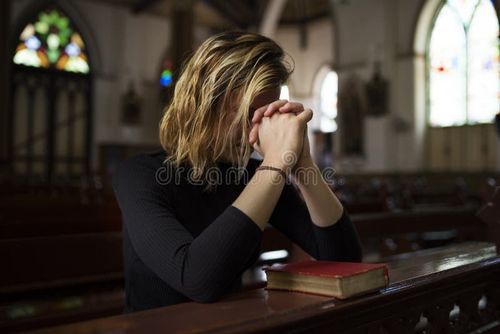 Mulher sentada na igreja orando. Imagens de religião, fotos e imagens livres de direitos autorais