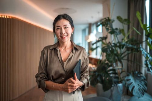 smiling female korean corporate employee with digital device - beautiful professional woman stock pictures, royalty-free photos & images