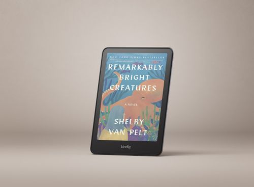 Kindle Colorsoft upright showing the book “Remarkably Bright Creatures” by Shelby Van Pelt on its screen.