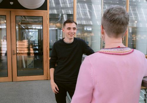 student and lecturer standing together talking
