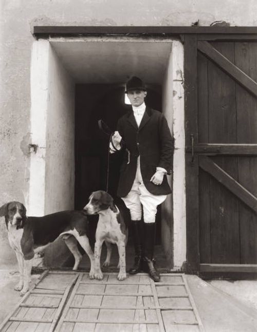 Huntsman with two hounds, circa 1900.