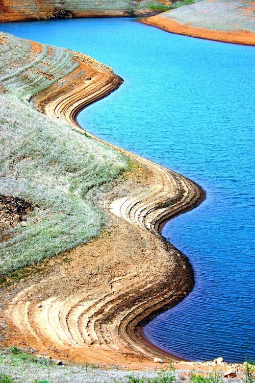 Shapes of nature, contrast between the brown of the sand and the blue of the water. Nature stock images, royalty-free photos and pictures