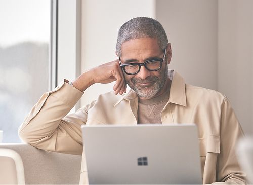 一人面带笑容看着笔记本电脑。