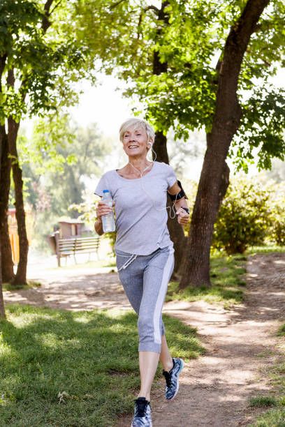 active senior woman jogging in park - old lady jogging stock pictures, royalty-free photos & images