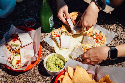 friends sharing tacos in outdoor restaurant - mexican food stall stock pictures, royalty-free photos & images