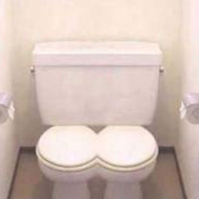 two white toilets sitting in a bathroom next to each other with their lids closed and the seat up