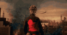 a man in a black jacket with a red circle on the back is standing in front of a city