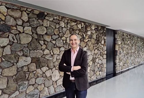 Matt Candy 在石墙背景前面向镜头微笑