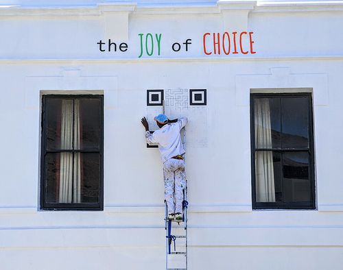 A QR code being painted on the side of a building