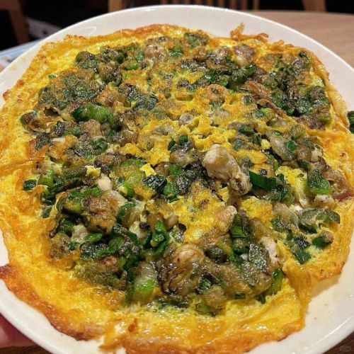 A vendor preparing traditional Fujian oyster omelette in Quanzhou market