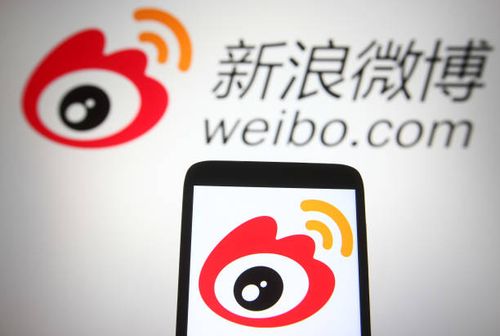 In this photo illustration a Weibo logo of a Chinese social media platform is seen on a smartphone and a pc screen.