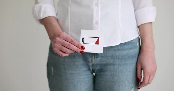 Woman holding low battery sign to her genitals closeup 4k movie slow motion. Decreased libido in women concept