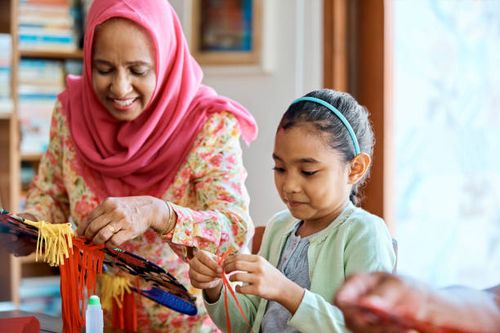 senior woman and girl making wau bulan at home - making wau stock pictures, royalty-free photos & images