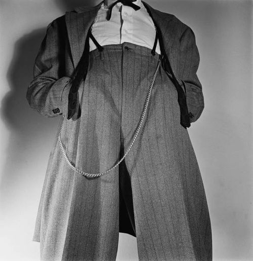 Low angle view of a man wearing a Zoot suit with a watch chain hanging from the waist, his hands in his pockets, United States, circa 1945.