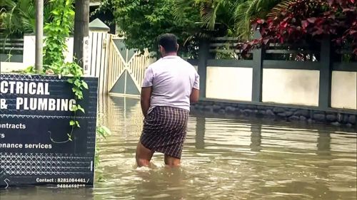 A man wades through a waterlogged area after heavy rain in Kerala. (Image:ANI)