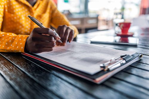She's got month end reporting down to a fine art Close-up Of Businesswoman's Hand Signing On Papers Over Desk while sitting during the day. Filling out an important form. American woman working at home. Focus on hand. Close up. she stock pictures, royalty-free photos & images
