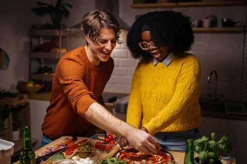 young couple preparing homemade pizza at home - night kitchen stock pictures, royalty-free photos & images