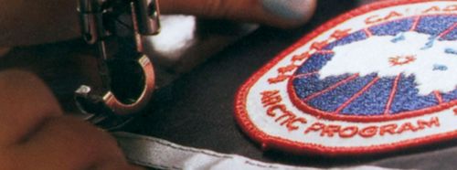 Craftsman stitching Canada Goose logo onto a product