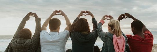 Photo friends making love heart hands at the beach