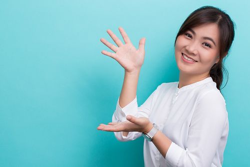 在蓝色背景下微笑的年轻女子的肖像图片下载