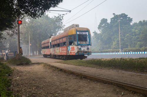 KOLKATA, INDIA - DECEMBER 12, 2016: A heritage and historic Calcutta tram moves through the Kolkata Maidan area on a foggy winter morning. Kolkata tram stock images, royalty-free photos and pictures
