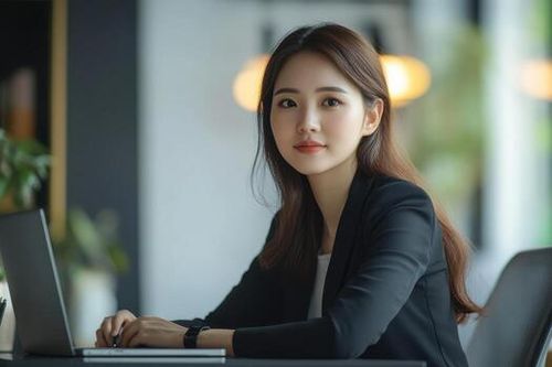 A professional woman sitting at a desk with a laptop, engaged in work. photo