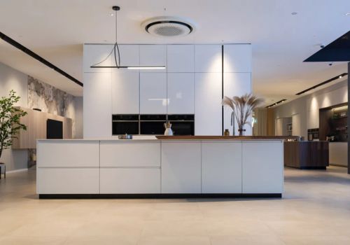 Minimalist kitchen island with sleek, modern design and clean lines, featuring a waterfall edge countertop for a seamless and elegant look. This design emphasizes simplicity and functionality, creating an airy and spacious ambiance perfect for a contemporary kitchen