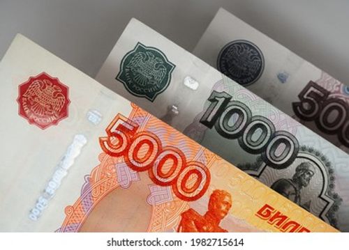 Russian banknotes 5000, 1000 and 500 rubles close up. Bright expressive illustration about economy and money of Russia. Nearest bill is highlighted in vivid color, other notes are pale. Macro Stock Photo