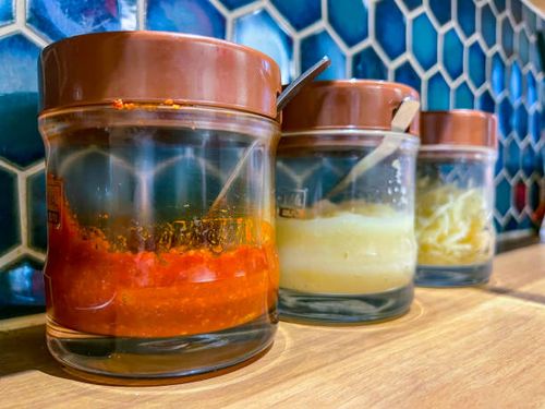 szechwan doubanjiang, grated garlic and pickled ginger in glass jars, served on counter table at ramen restaurant in motomachi - douban stock pictures, royalty-free photos & images