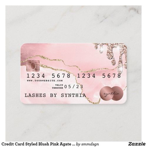 a pink and gold credit card with two circles on the front, in white marble