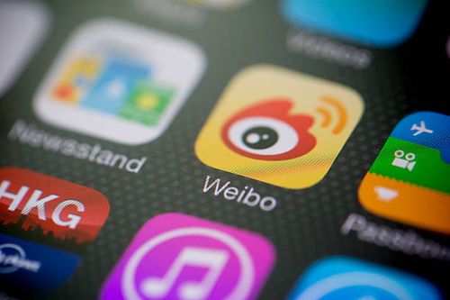 Sina Corp.'s Sina Weibo microblogging service app icon is displayed on an Apple Inc. IPhone 5s in an arranged photograph in Hong Kong, China, on...