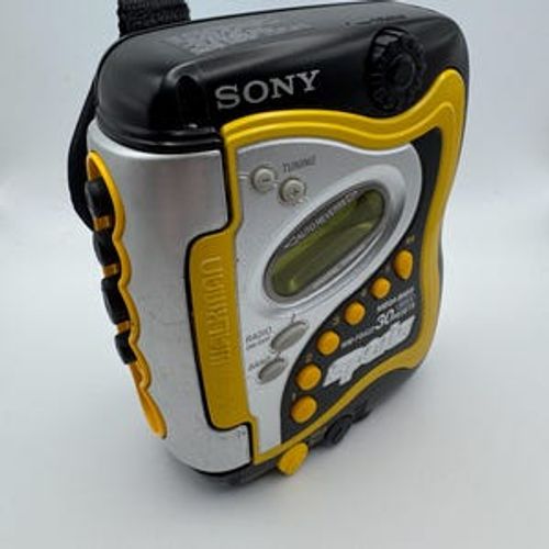 May include: A black, silver, and yellow Sony WM-FS420 Sports Walkman radio cassette player. The portable stereo features a digital tuning display, buttons for radio, and a Mega Bass function. The Walkman has a black strap.