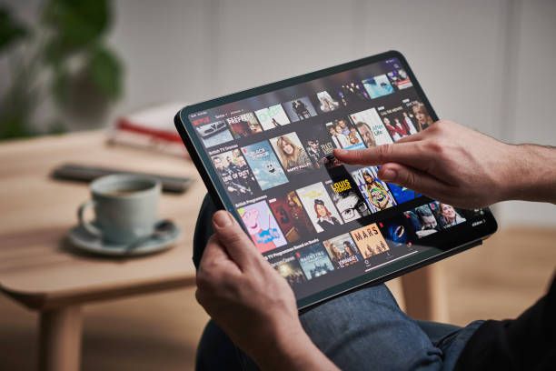 Detail of a mans hand scrolling through Netflix on an Apple iPad Pro, taken on March 6, 2020.