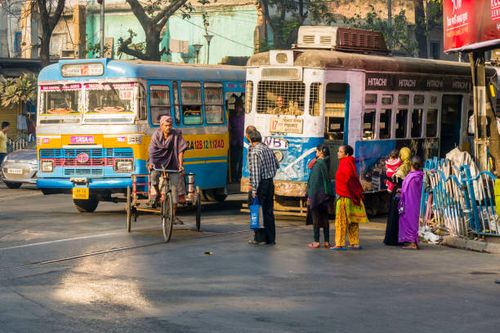 Bus, a cyclist and a tram on a busy road in the suburb Sealdah.