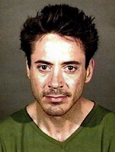 Mugshot of Downey, wearing a green shirt, looking directly at the camera with a slight smile