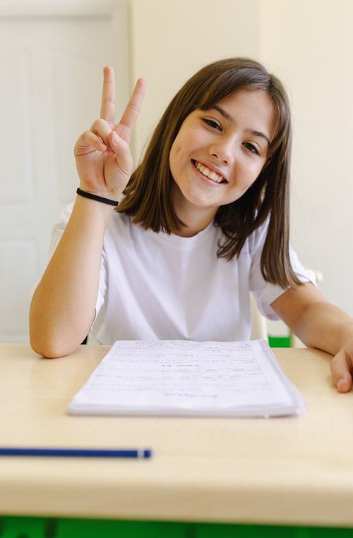 一个快乐的女学生坐在教室的课桌前照片下载