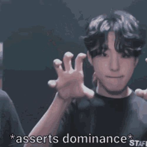 a man making a funny face with the words asserts dominance written below him