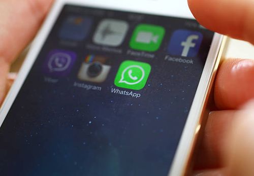 Launching WhatsApp on iPhone 5s. Wien,Austria-February 25,2014: Closeup of female hand holding an iPhone 5s while launching WhatsApp,a popular messaging application . whatsapp mobile stock pictures, royalty-free photos & images