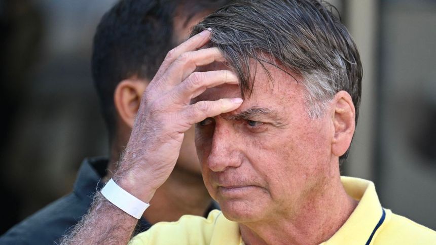 Former Brazilian President Jair Bolsonaro gestures after taking medical tests at DF Star hospital in Brasilia on August 16, 2025. A Brazilian Supreme Court judge granted Bolsonaro's request to have his house arrest temporarily lifted so the former president can undergo a series of medical tests. On August 4, 2025, Bolsonaro was placed under house arrest for violating a court order prohibiting the use of social media as part of his trial over an alleged coup attempt. (Photo by Evaristo SA / AFP) 