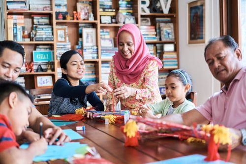multi-generation family making wau bulan at table - making wau stock pictures, royalty-free photos & images