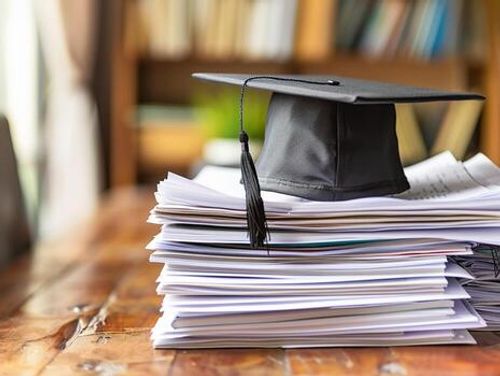 A graduation bachelor cap on a stack of paper, new graduate job hunting concept. photo