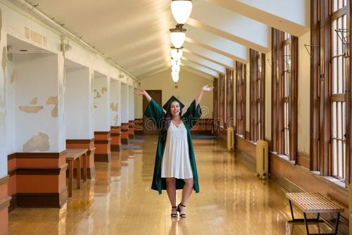 University graduate on her college campus in a cap and gown celebrating graduating from her undergrad bachelor`s degree during the Spring. Bachelor s degree stock images, royalty-free photos and pictures