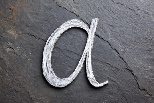 Letter a in White Chalk on Dark Textured Slate Background photo