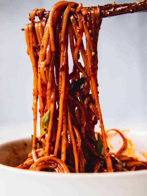 Lifting chili oil garlic noodles with chopsticks.